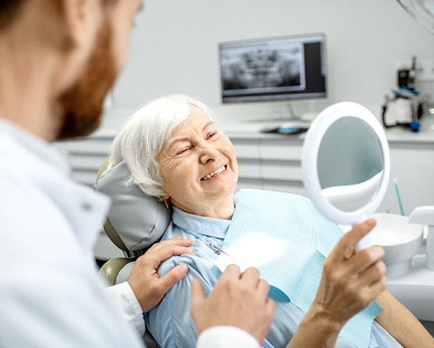 woman smiling after working with an implant dentist in West Seneca