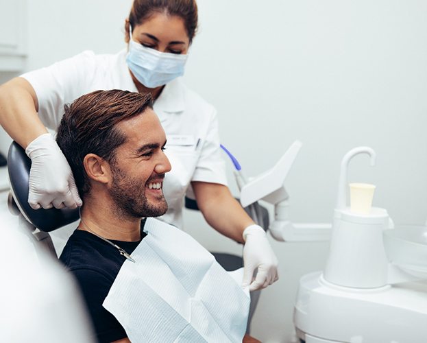 smiling dental patient getting out of the dental chair