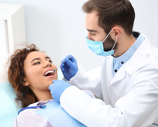 Dentist checking patient for oral cancer