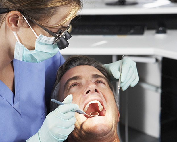 Dentist performing oral cancer screening