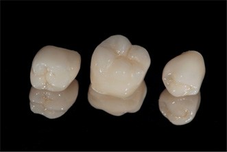 three dental crowns with a black background 