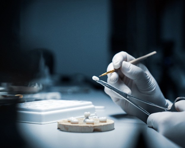 dental lab technician’s hands crafting a dental crown  