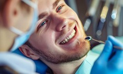 Man smiling while dentist examines his teeth