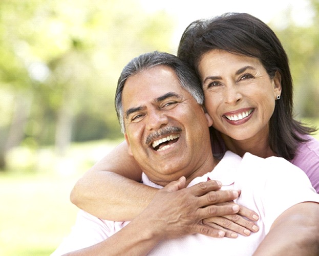 couple hugging and smiling with dental implants in West Seneca