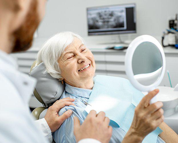 Woman admiring her new dental implants in West Seneca