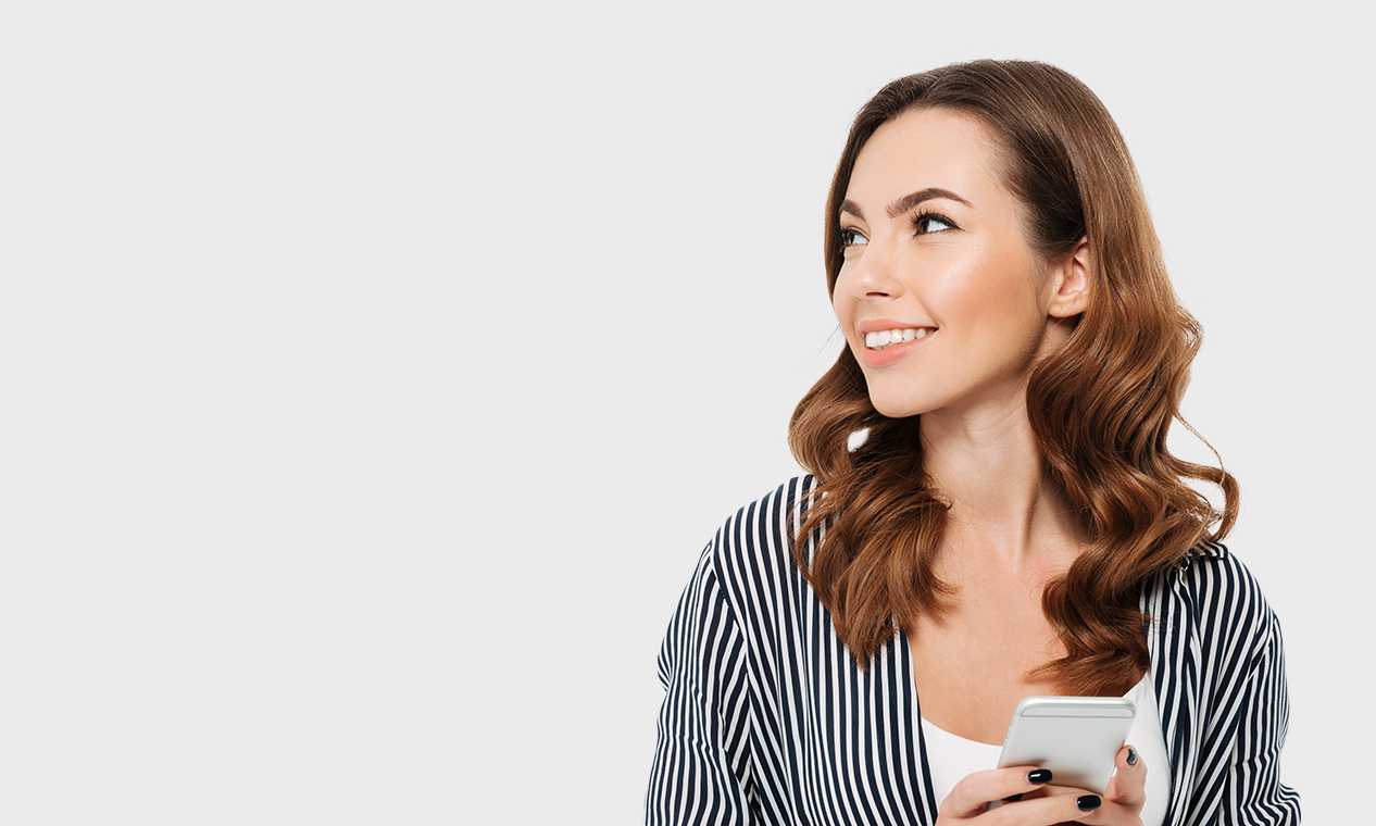 Woman holding cell phone while looking off into distance