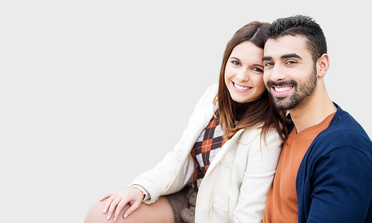 Young man and woman smiling and hugging