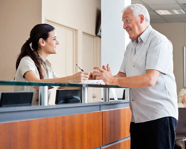 Older dental patient filling out dental insurance forms