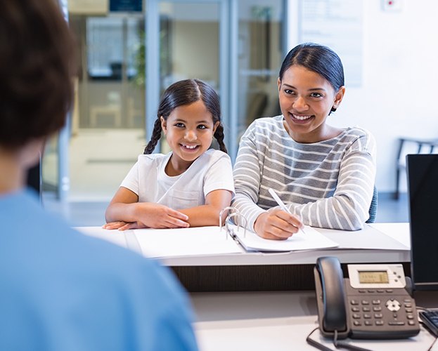 Mother and daughter filling out dental insurance forms