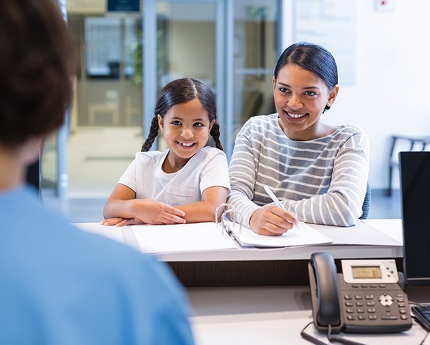 Mother and daughter filling out dnetal insurance forms