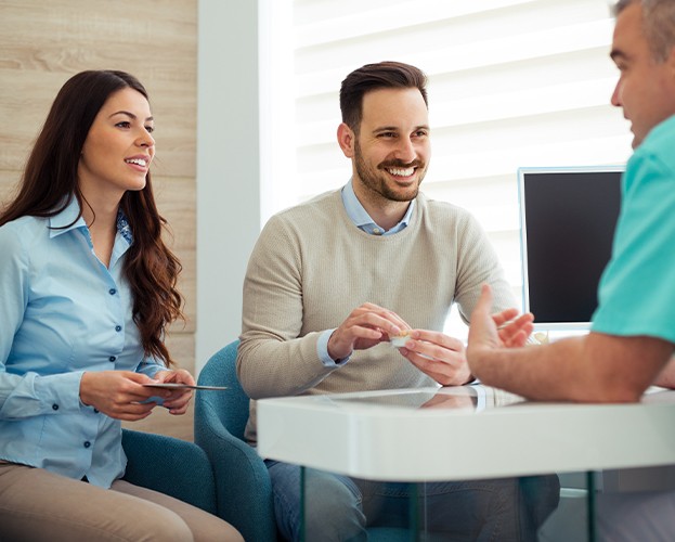 Two people discussing dental insurance coverage with their dentist