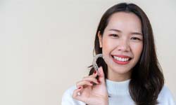 woman holding Invisalign aligner