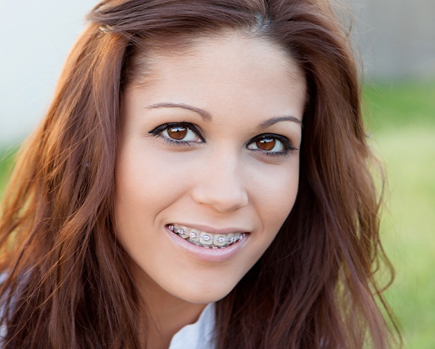 Woman with traditional bracket and wire braces orthodontics