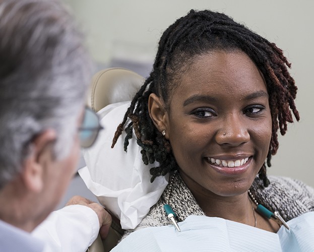 Patient smiling at dentist during dental checkup and teeth cleaning visit