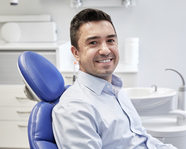 Smiling man in dental chair after root canal therapy