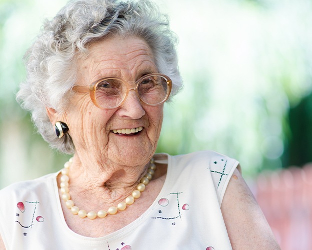 Older woman smiling after visiting dentist for seniors in West Seneca