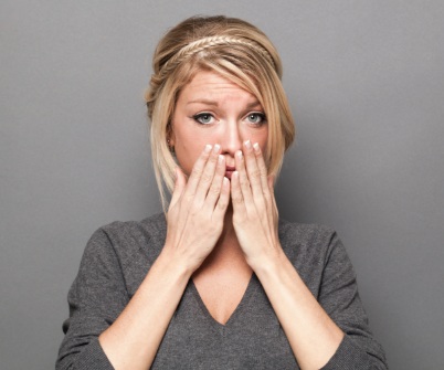 Fearful patient in need of sedation dentistry covering mouth