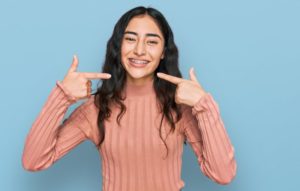 young woman pointing at her braces