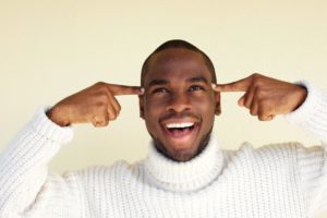 man smiling and pointing to his head