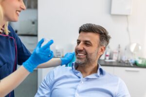 middle-aged man smiling and getting Invisalign